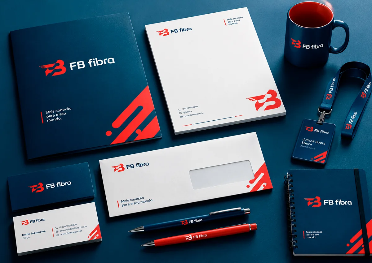 Simulação de papelaria da FB fibra: pasta, papel timbrado, envelope, cartões de visita, canetas, caneca, crachá com cordão e caderno, em azul-marinho e vermelho