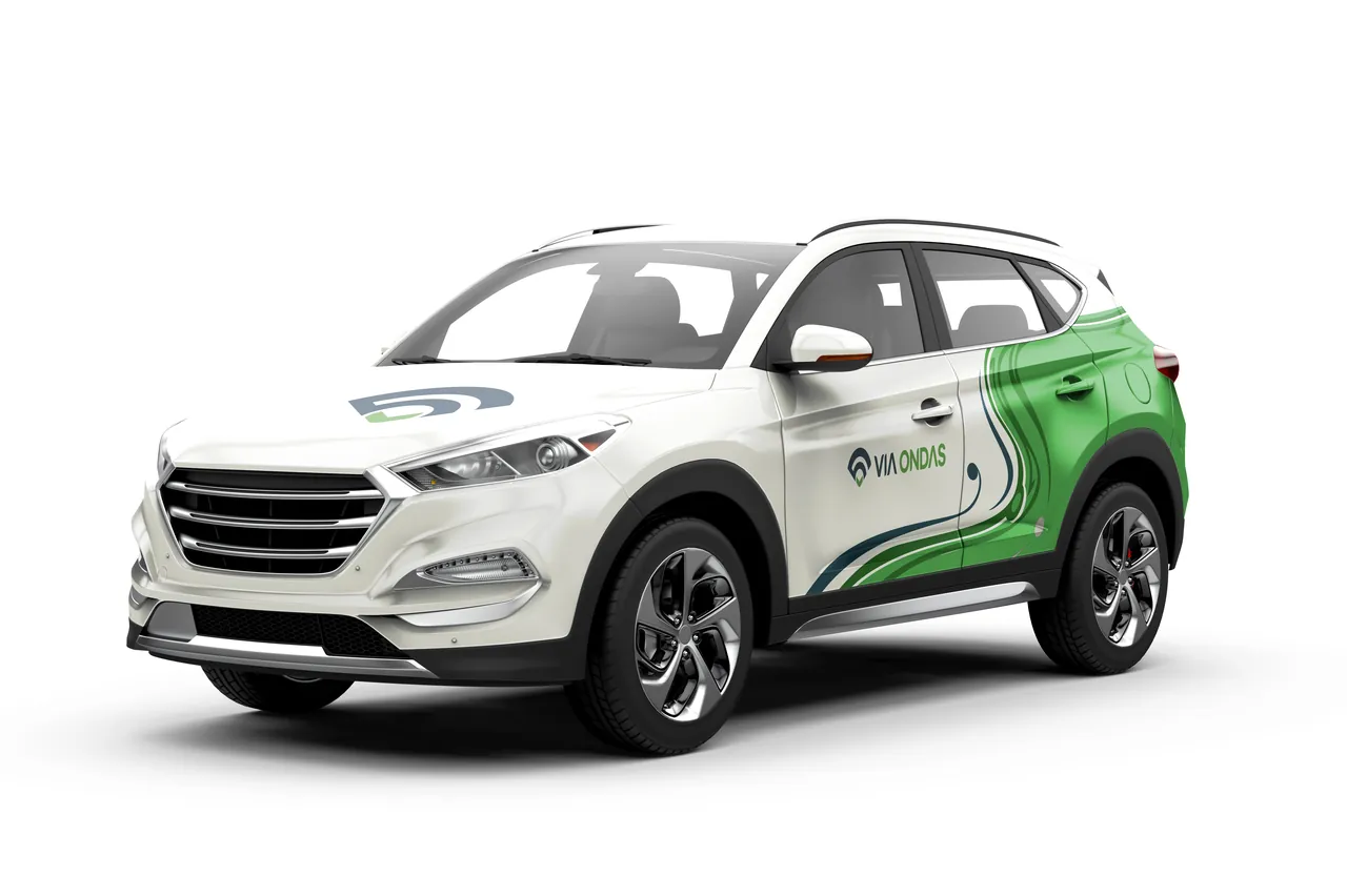 Carro branco com plotagem da Via Ondas em verde e azul, visto de frente e de lado, sobre fundo branco